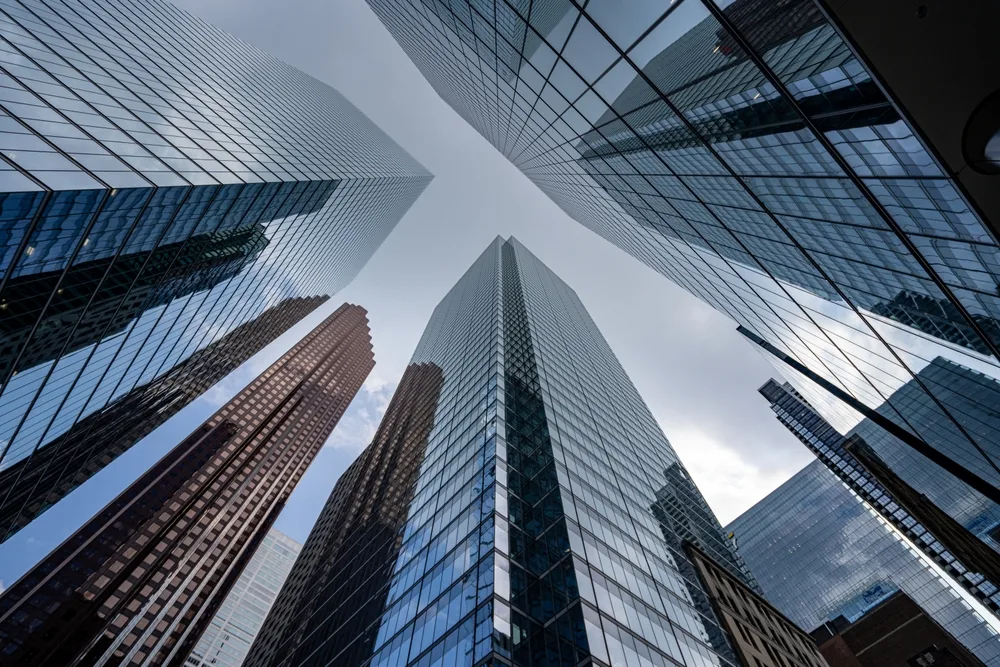 Glass bank towers seen from street level, looking straight up